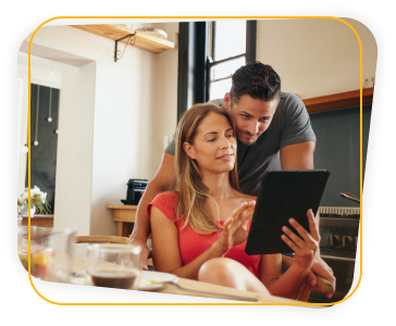 Casal em uma cozinha com tablet na mão fazendo uma pesquisa 