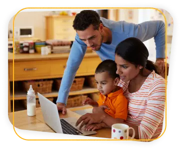 Casal com o filho em uma casa Um casal com o filho em uma casa pesquisando informações no notebook